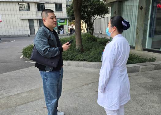 穿白色衣服的男人在街道边走描述已自动生成